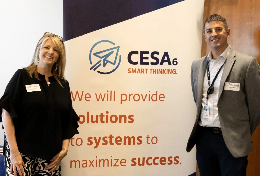 Two professionals standing beside a CESA 6 promotional banner with text about providing solutions and success.