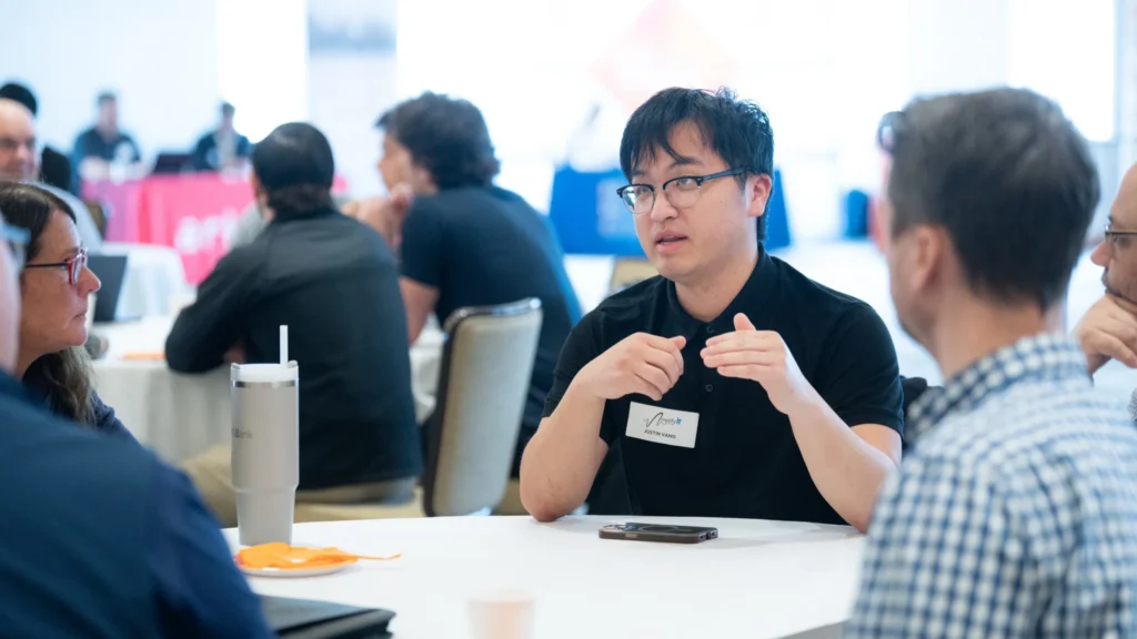 Group of professionals engaged in discussion at a round table during a conference or meeting.